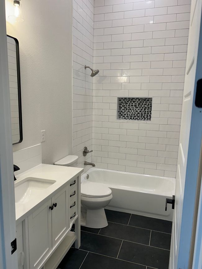 Bathroom with vanity, tile patterned floors, washtub / shower combination, and toilet | Image 22