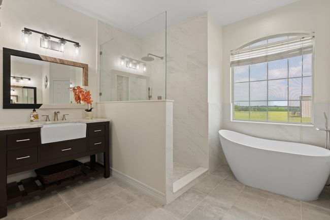 Newly remodeled primary ensuite. Separate vanities, large walk in shower, spa like soaking tub and more natural light! Frist of two closets is to the left of the vanity. | Image 23
