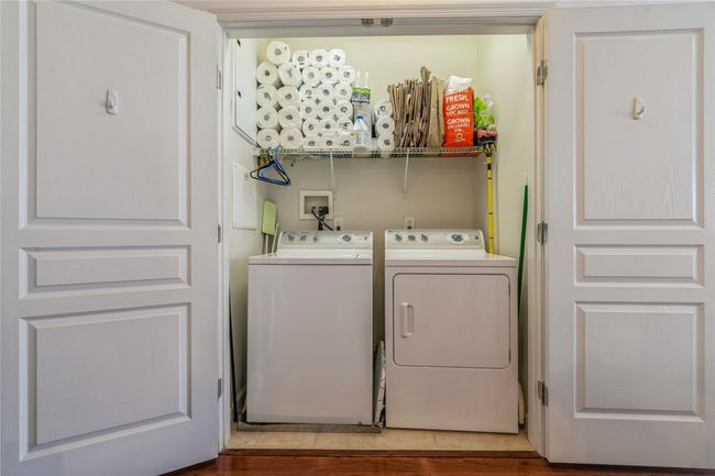 Laundry area featuring laundry area, washing machine and clothes dryer, and wood finished floors | Image 7