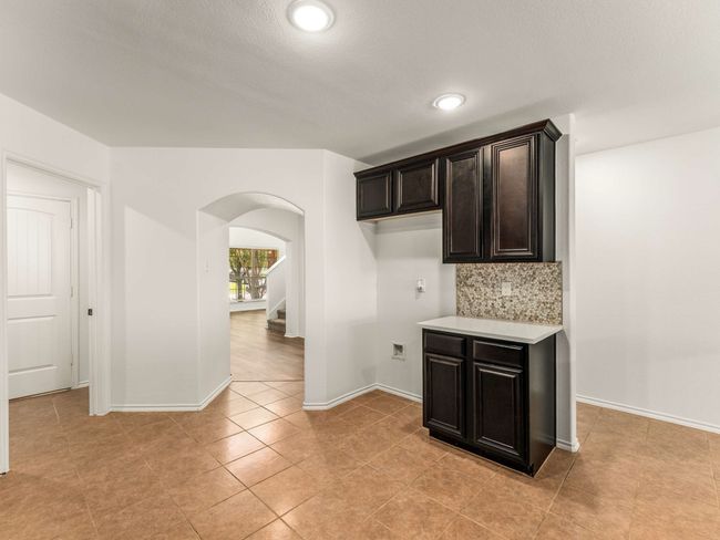 Kitchen with arched walkways, light countertops, tasteful backsplash, light tile patterned flooring, and recessed lighting | Image 17