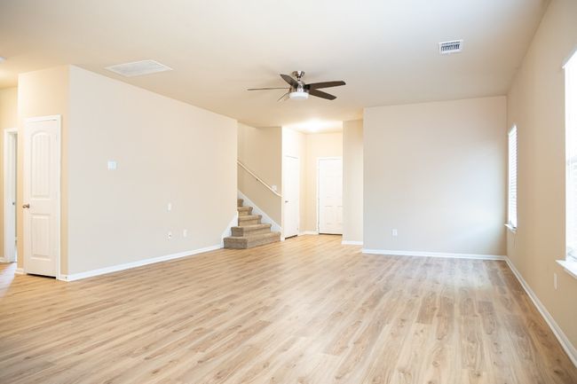 Spare room with ceiling fan, stairway, light wood-type flooring, and baseboards | Image 4