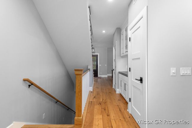 Beautiful staircase with custom handrail leads to the second floor. | Image 23