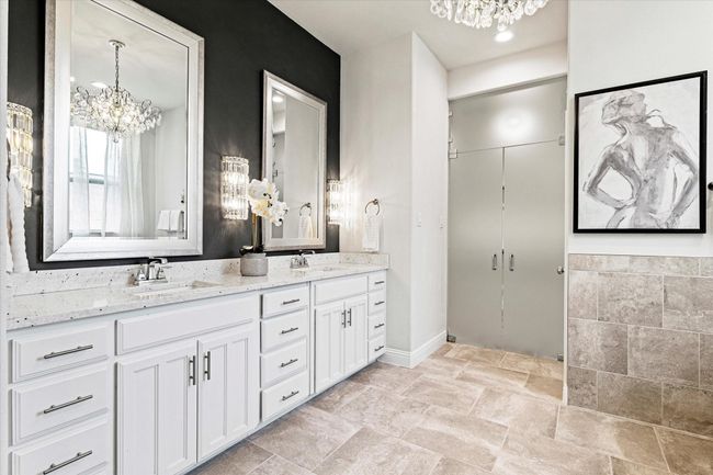 Bathroom with a chandelier, double vanity, and stone tile flooring | Image 21