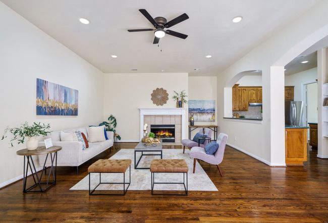 Living area with baseboards, a fireplace, ceiling fan, recessed lighting, and wood floors | Image 8