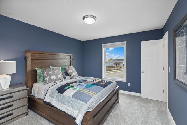 Photo is of the actual model. One of three generously sized upper-level secondary bedrooms with spacious closets. | Image 20