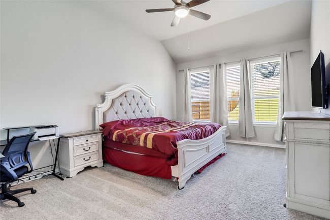 Bedroom featuring light carpet, lofted ceiling, a ceiling fan, and baseboards | Image 20