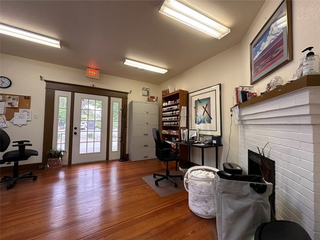 Home office featuring wood finished floors and a fireplace | Image 11