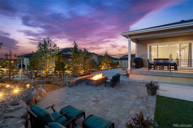 Custom landscaping with professional lighting, Belgard paver entertaining area, pond w/waterfalls, built-in 72" fireplace with seating bench, sports area, storage shed, mature trees and additional gas lines for whatever your heart desires | Image 5