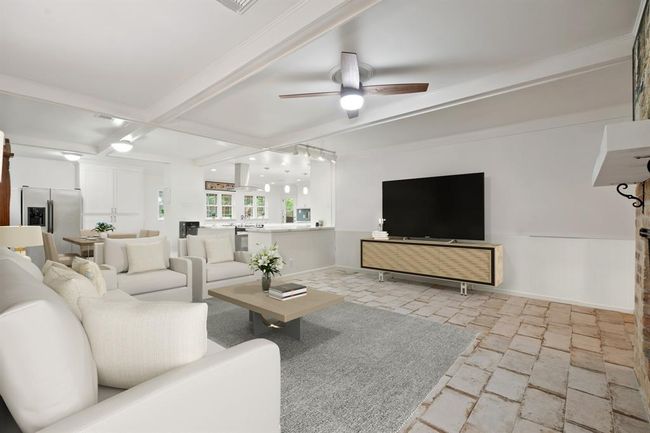 This home has been revitalized with a semi-open concept with seamless access to the kitchen and dining spaces. | Image 6