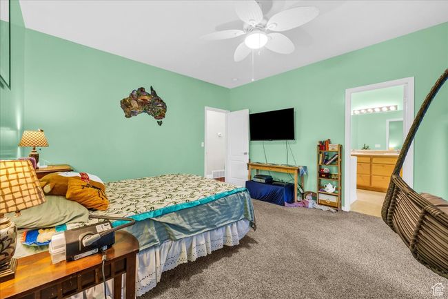 Carpeted bedroom featuring ceiling fan and ensuite bath | Image 18