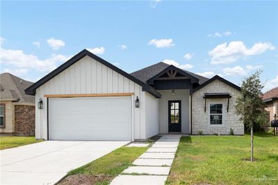 View of front facade with a garage and a front yard | Image 1