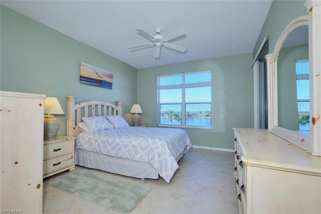 Bedroom featuring ceiling fan, a water view, and light tile patterned flooring | Image 33
