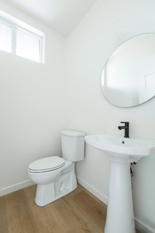 Half bathroom featuring toilet and wood finished floors | Image 12