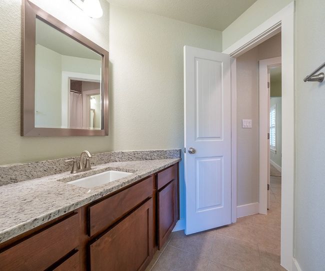Bathroom featuring vanity, light tile patterned flooring, and a textured wall | Image 20