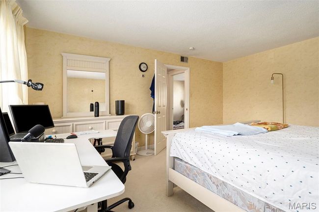Bedroom featuring light colored carpet and a desk | Image 15