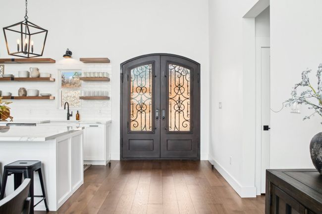 Bar area featuring french doors, arched walkways, dark wood-style flooring, and decorative light fixtures | Image 6