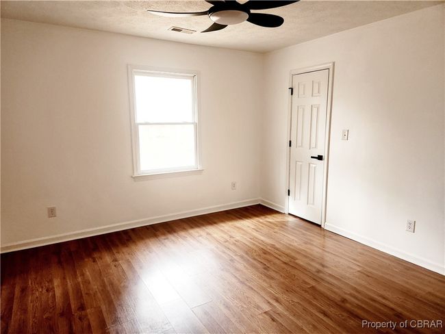 Empty room featuring hardwood / wood-style floors, a textured ceiling, and ceiling fan | Image 10