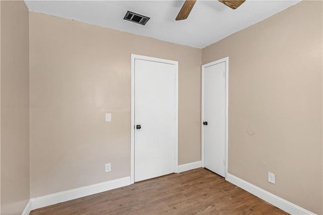 Unfurnished bedroom featuring visible vents, ceiling fan, baseboards, and wood finished floors | Image 13