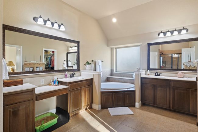 Full bath featuring a garden tub, a shower stall, vaulted ceiling, and a sink | Image 23