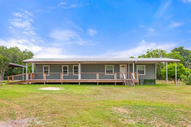 View of front of property featuring a front lawn and metal roof | Image 13