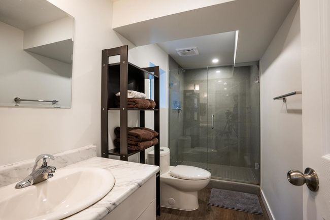Bathroom with toilet, wood finished floors, visible vents, a shower stall, and vanity | Image 29