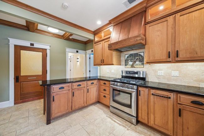 THIS VIEW OFFERS A LOOK TOWARDS THE STUNNING POWDER ROOM WITH CUSTOM WOOD DOOR MOLDING AND WOOD DETAILED CEILING ABOVE IN THE HALLWAY | Image 18