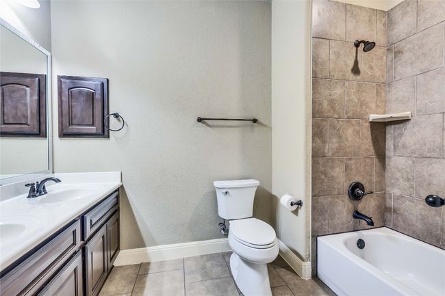 Full bath with double vanity, shower / bathtub combination, and tile patterned flooring | Image 13