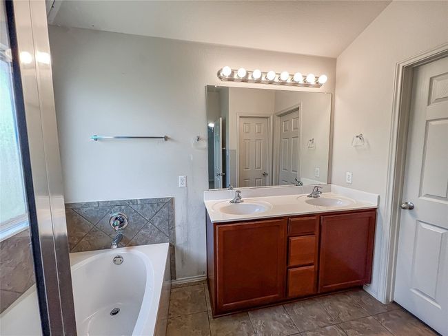 Full bath with double vanity, a bath, and tile patterned floors | Image 23