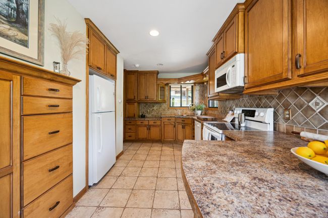 Another photo of the kitchen showing the added cabinets on the other side of the counter and next to the refrigerator. | Image 10