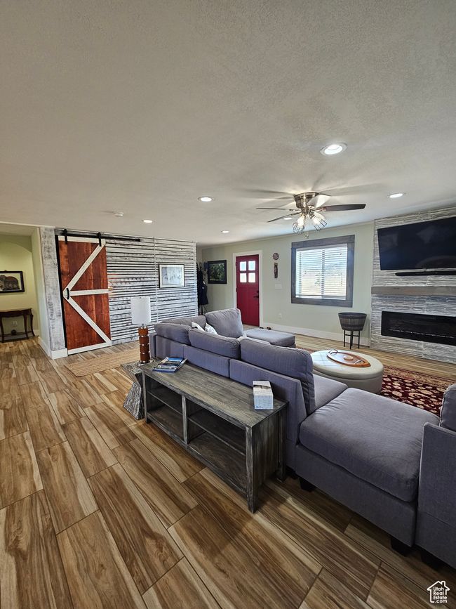 Living room with a ceiling fan & stone glass fireplace | Image 26