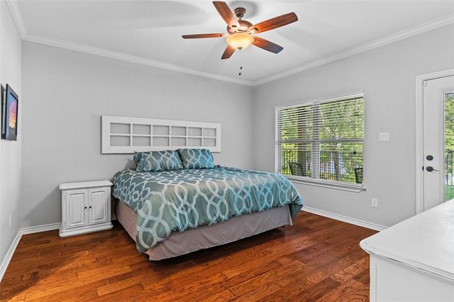 Bedroom with ceiling fan, dark hardwood / wood-style flooring, access to exterior, and ornamental molding | Image 7