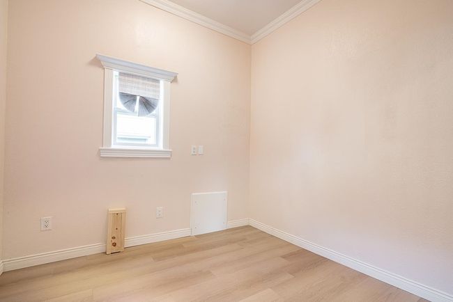 Empty room featuring light wood-style flooring and crown molding | Image 16
