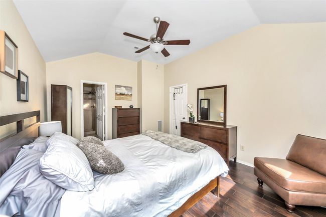 Bedroom featuring vaulted ceiling, dark wood-style flooring, baseboards, and ceiling fan | Image 19