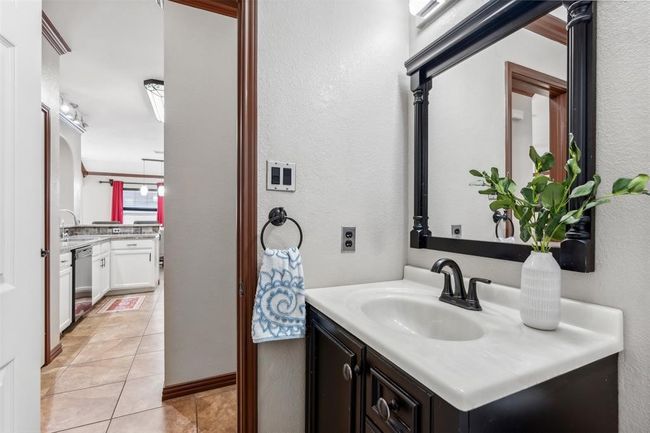 Bathroom featuring tile patterned flooring, vanity, and a textured wall | Image 8