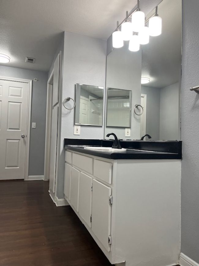 Bathroom featuring baseboards, vanity, wood finished floors, and visible vents | Image 21