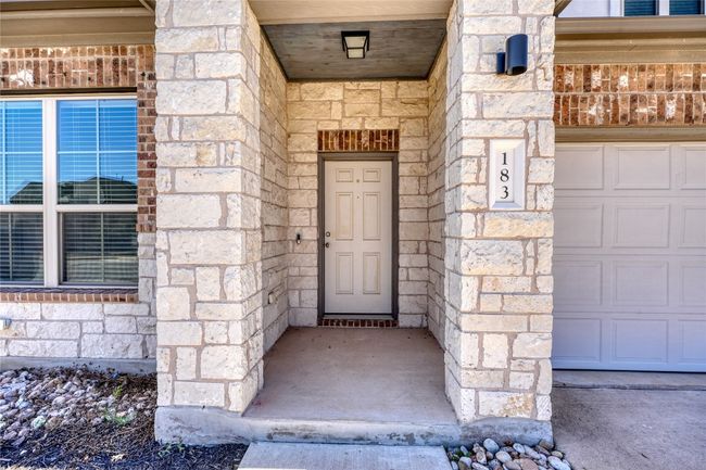 Entrance to property with a garage and stone siding | Image 4