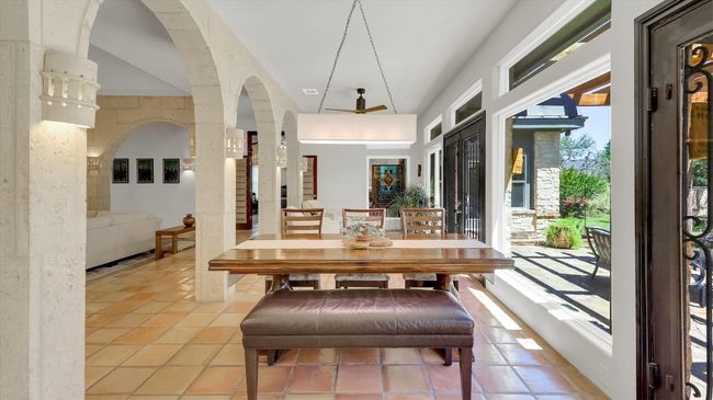 Dining area featuring arched walkways, light tile patterned flooring, and a towering ceiling | Image 9