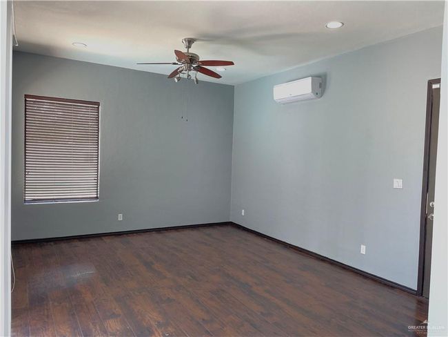 Empty room featuring an AC wall unit, a ceiling fan, dark wood-type flooring, recessed lighting, and baseboards | Image 18