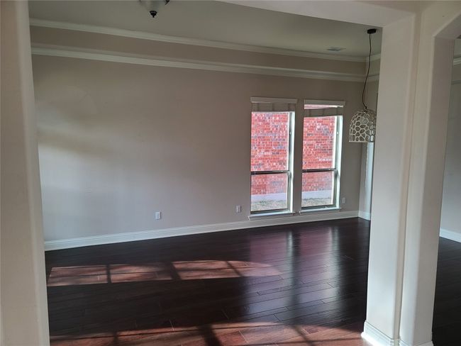 Empty room featuring dark wood-style floors and ornamental molding | Image 4