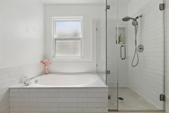 The luxurious soaking tub invites you to unwind, while the walk-in shower features updated shower heads and faucets. | Image 18