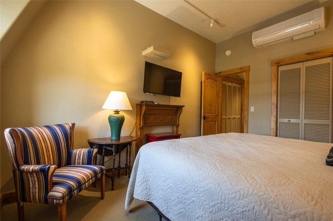Bedroom featuring a wall mounted AC, carpet flooring, and rail lighting | Image 16