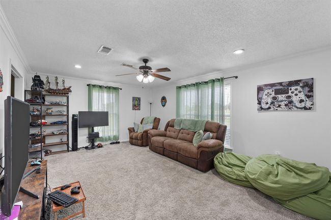 Carpeted living room with ornamental molding, ceiling fan, a textured ceiling, and recessed lighting | Image 24