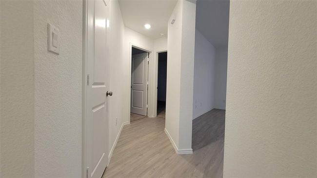 Corridor featuring a textured wall and light wood-style flooring | Image 18
