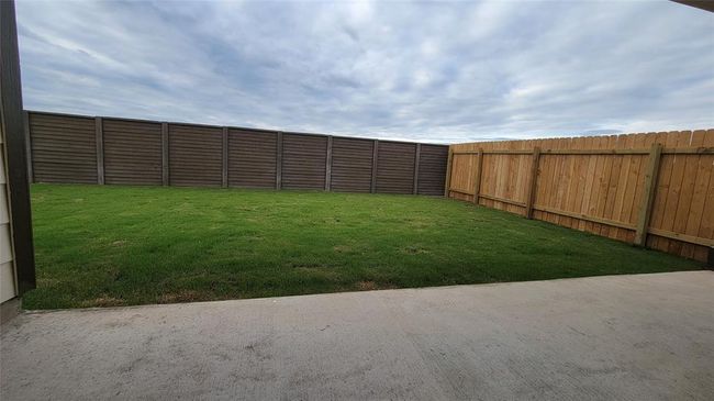 Fenced backyard with a patio | Image 19