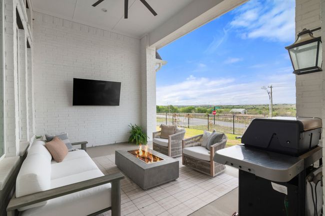 View of patio with an outdoor living space with a fire pit, area for grilling, and a ceiling fan | Image 34
