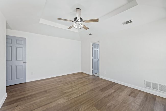 Spare room with wood finished floors, baseboards, ceiling fan, and visible vents | Image 28