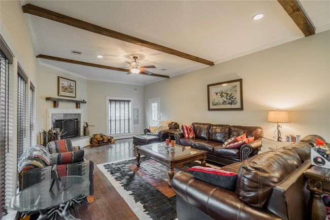 Beautiful Cherry wood floors, Ceiling beams are 6" X 6" Red Oak, Gorgeous over sized wood burning fireplace w/a very special old mantle hanging above the fireplace, Recessed lighting, Ceiling fans, Crown molding, very thick glass windows, and Blinds on the windows round out this beautiful living room with lots of light and views of the Ranch. | Image 14