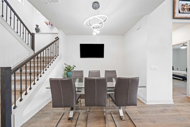 Dining space with a chandelier, stairs, baseboards, and wood finished floors | Image 12