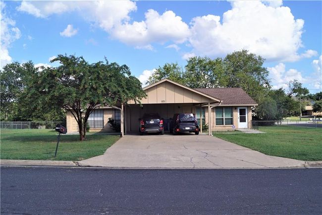 Single story home with concrete driveway, board and batten siding, and a carport | Image 20