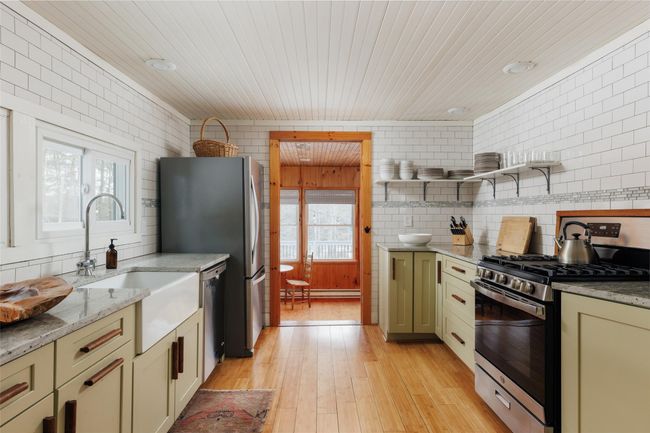 Kitchen featuring light stone countertops, light hardwood / wood-style flooring, stainless steel appliances, and a healthy amount of sunlight | Image 19